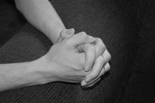 Black and white photo of hands praying