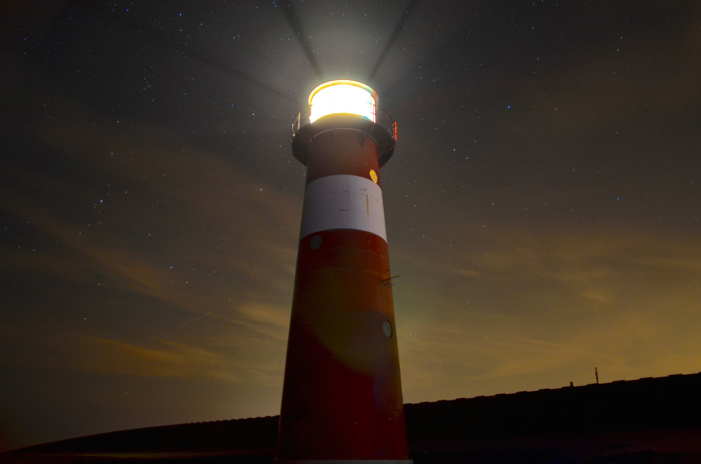 A lighthouse shining in the evening sky