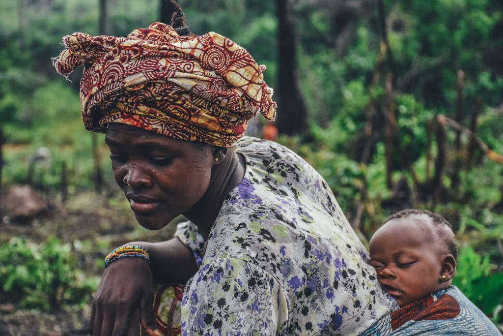 African woman with sleeping baby on back