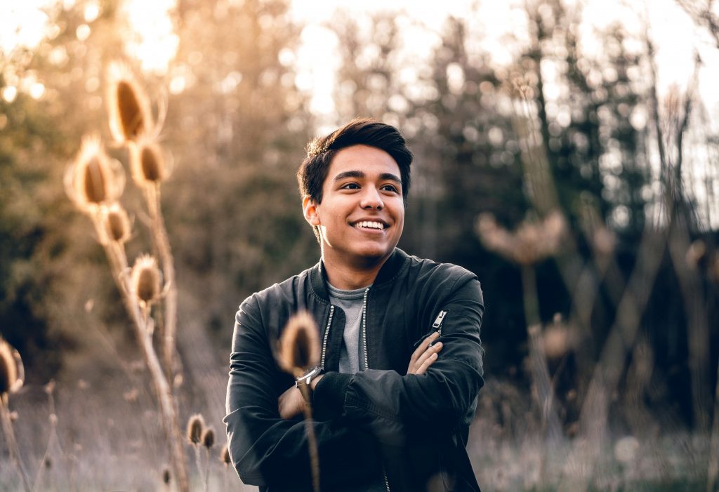 Young man smiling in a field.