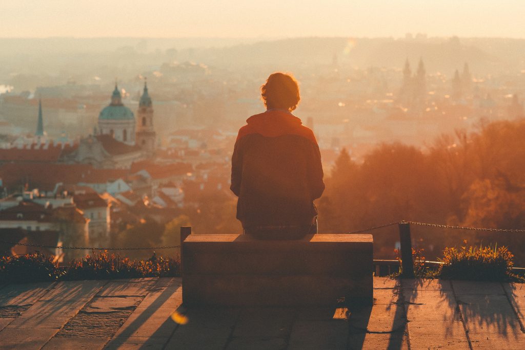 person looking at a view of old city and sunset