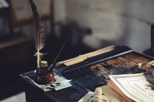desk with quill and paper