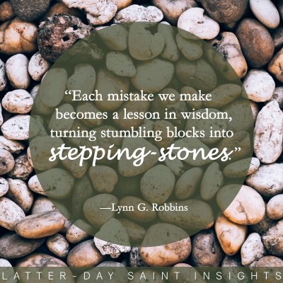 Full frame shot of pebbles with a quote by Lynn G. Robbins that says, "Each mistake we make becomes a lesson in wisdom, turning stumbling blocks into stepping stones."