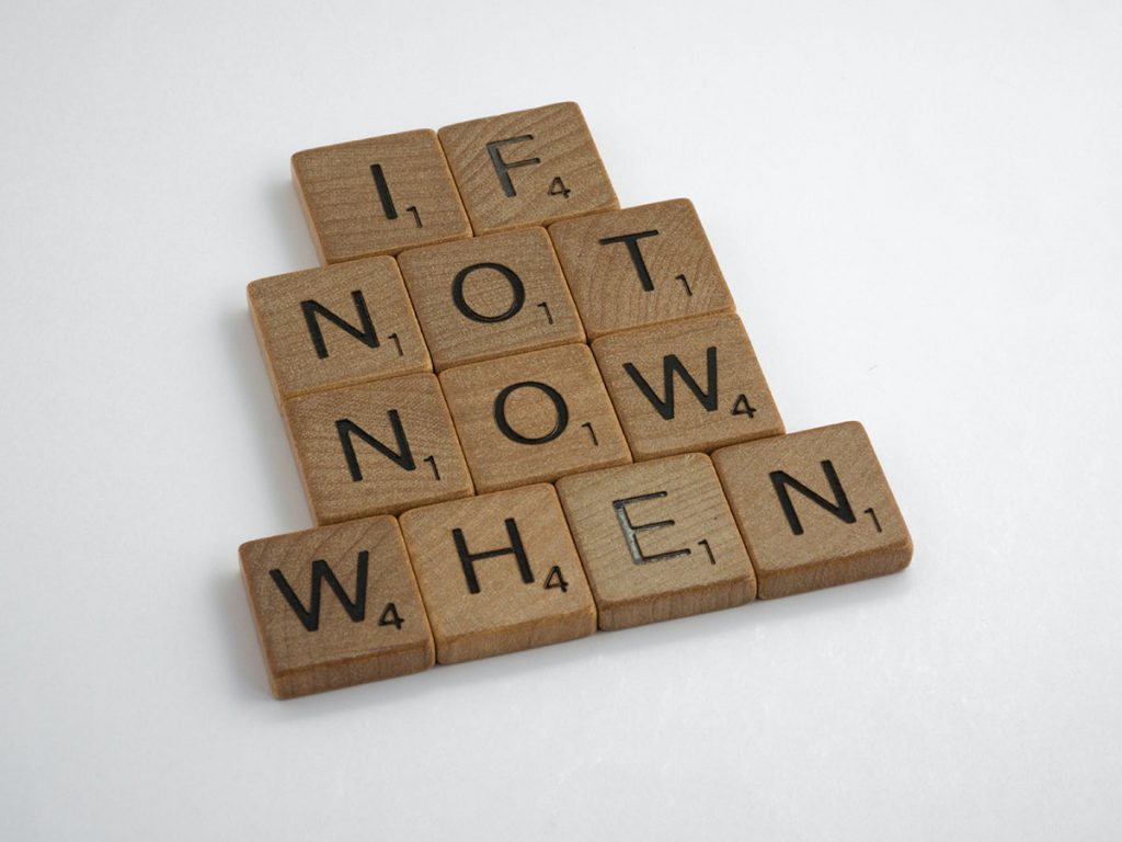 Twelve scrabble game squares that spell out, "If not now, when."