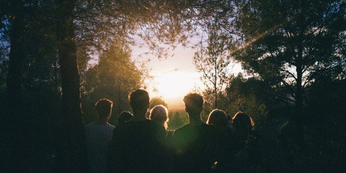 A group of people watch the sunset while camping in Cubelles, Spain
