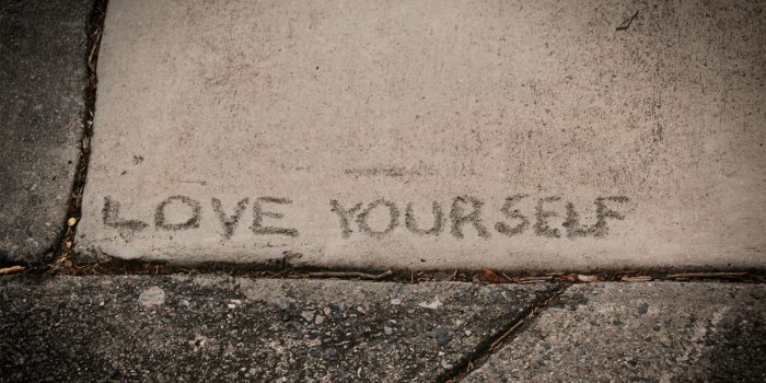 "Love Yourself" written in concrete.
