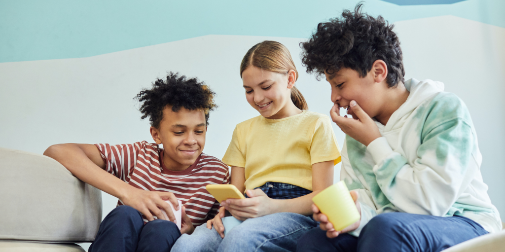 Three children play games on an electronic device
