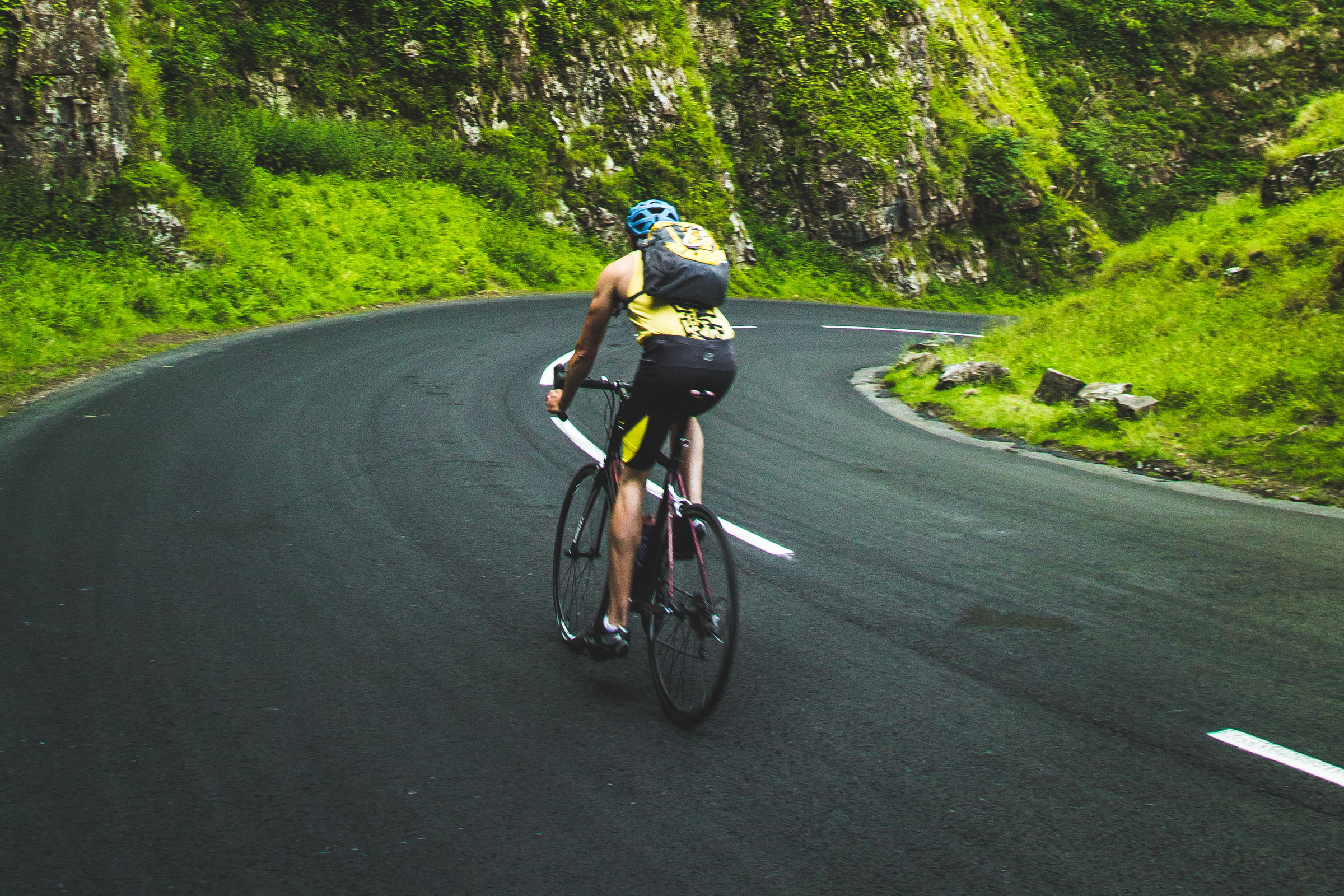 Person cycling on a grassy mountain road