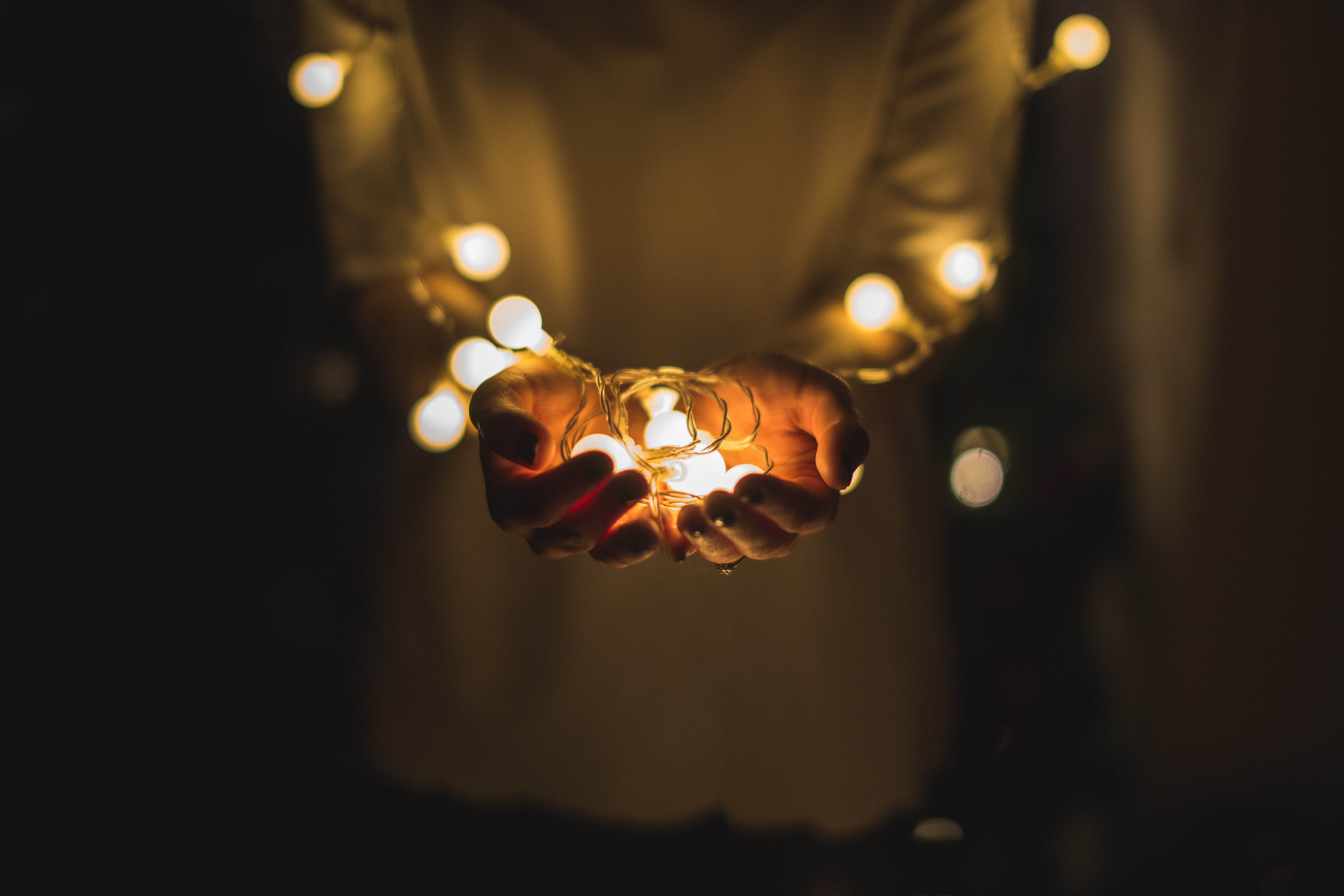 Person holding string lights in hands