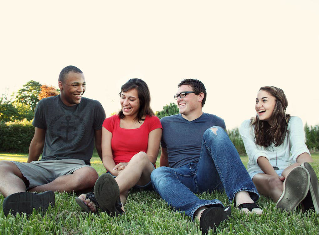 Group of smiling people sitting in grass