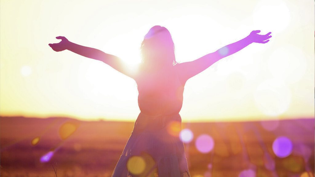Sun shining on girl in a field