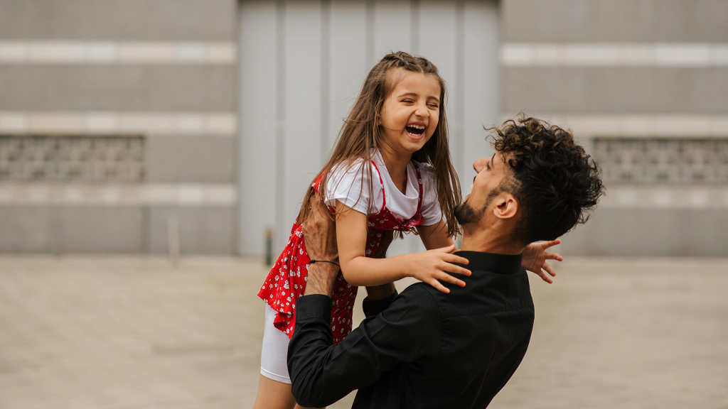 Father holding laughing little girl.