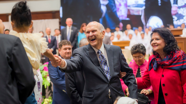 President Nelson of the LDS church shakes the hand of a child